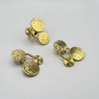 Boucles d'oreilles pendantes fantaisie couleur or avec trois disques texturés reliés par un ressort spiralé